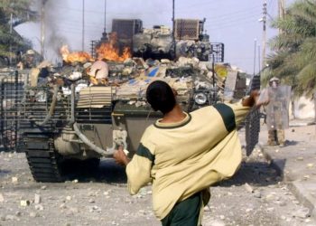 An Iraqi protester throws stones at British soldiers during clashes in the southern Iraqi city of Basra. 19 September 2005. Photo: AFP